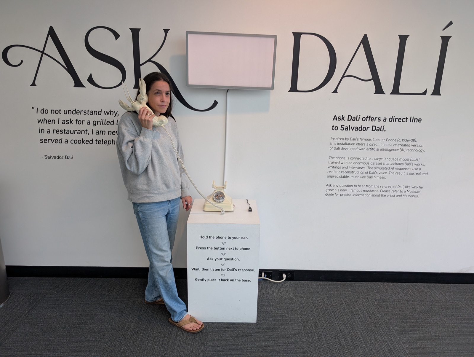 Jess holding the Ask Dalí phone at a museum installation